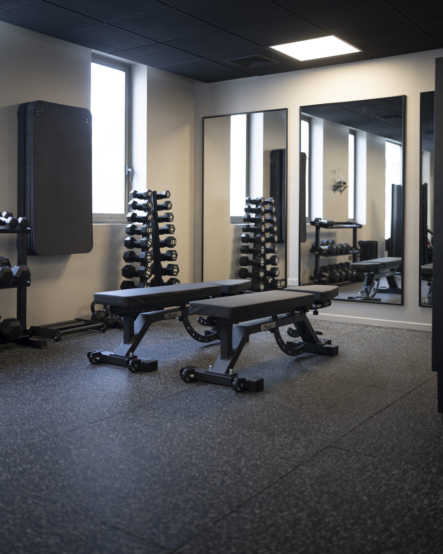 Sala de entrenamiento con rack olímpico y discos en MovaFit Studio